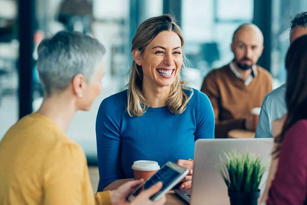 Woman with hearing loss laughing at work